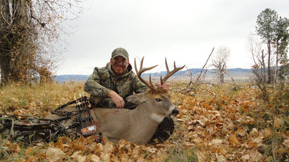 Hunter holding up dead deer