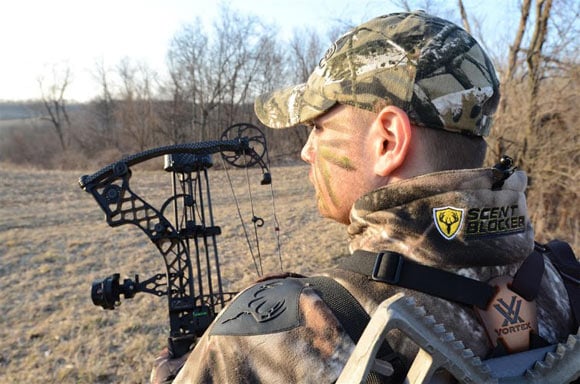 Profile View of hunter with bow looking into field