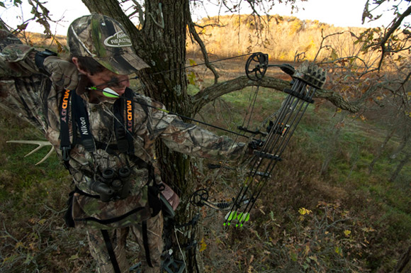 Hunter aiming up on tree stand