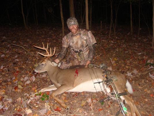 Hunter with dead deer in darkness