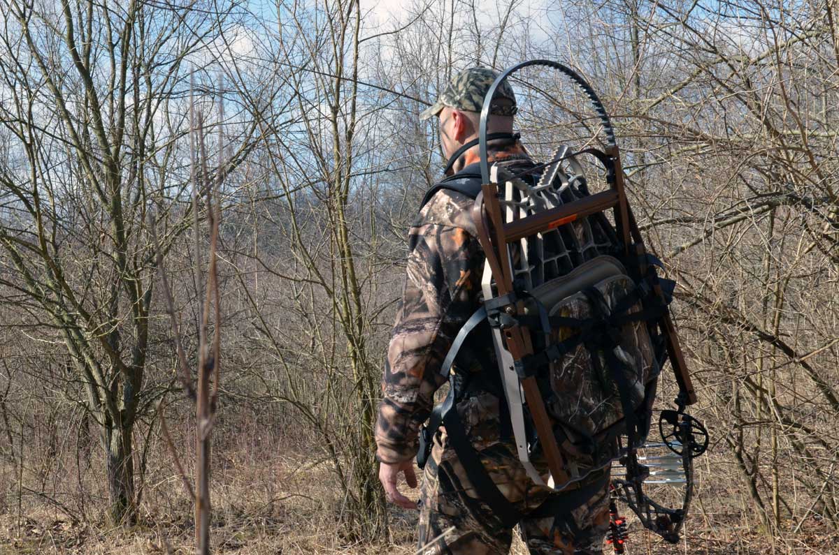 Hunter packing a climbing treestand on his back.