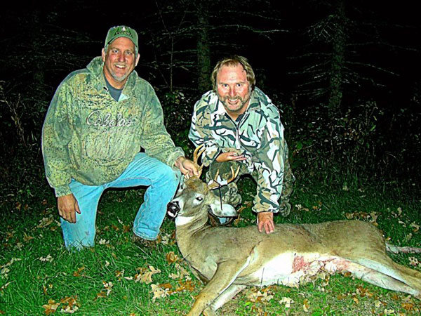 Hunter with buck Successful deer hunter with small buck