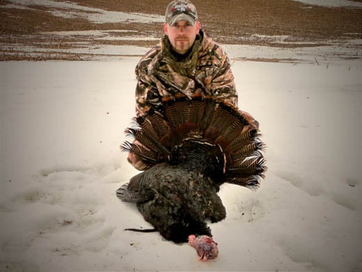 A hunter with an Arrowed Turkey
