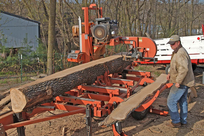A sawyer cuts lumber from a log that Patrick Durkin salvaged from a dead ash tree in his yard.