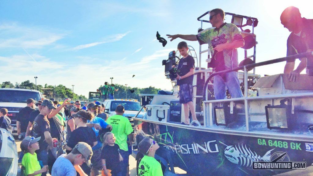 Bryan Hughes and Mark Land of Muzzy Bowfishing toss Muzzy swag to the over-anxious crowd of young bowfishermen. 