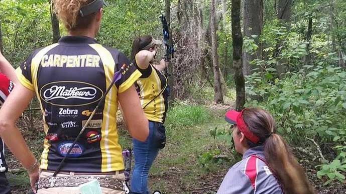 Kailey Johnston takes aim while teammate Sharon Carpenter looks on.