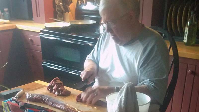 Dad cutting up some backstraps to enjoy for dinner. The fruits of a successful hunt.