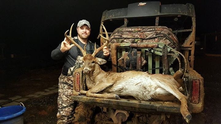 hunter with buck on tailgate