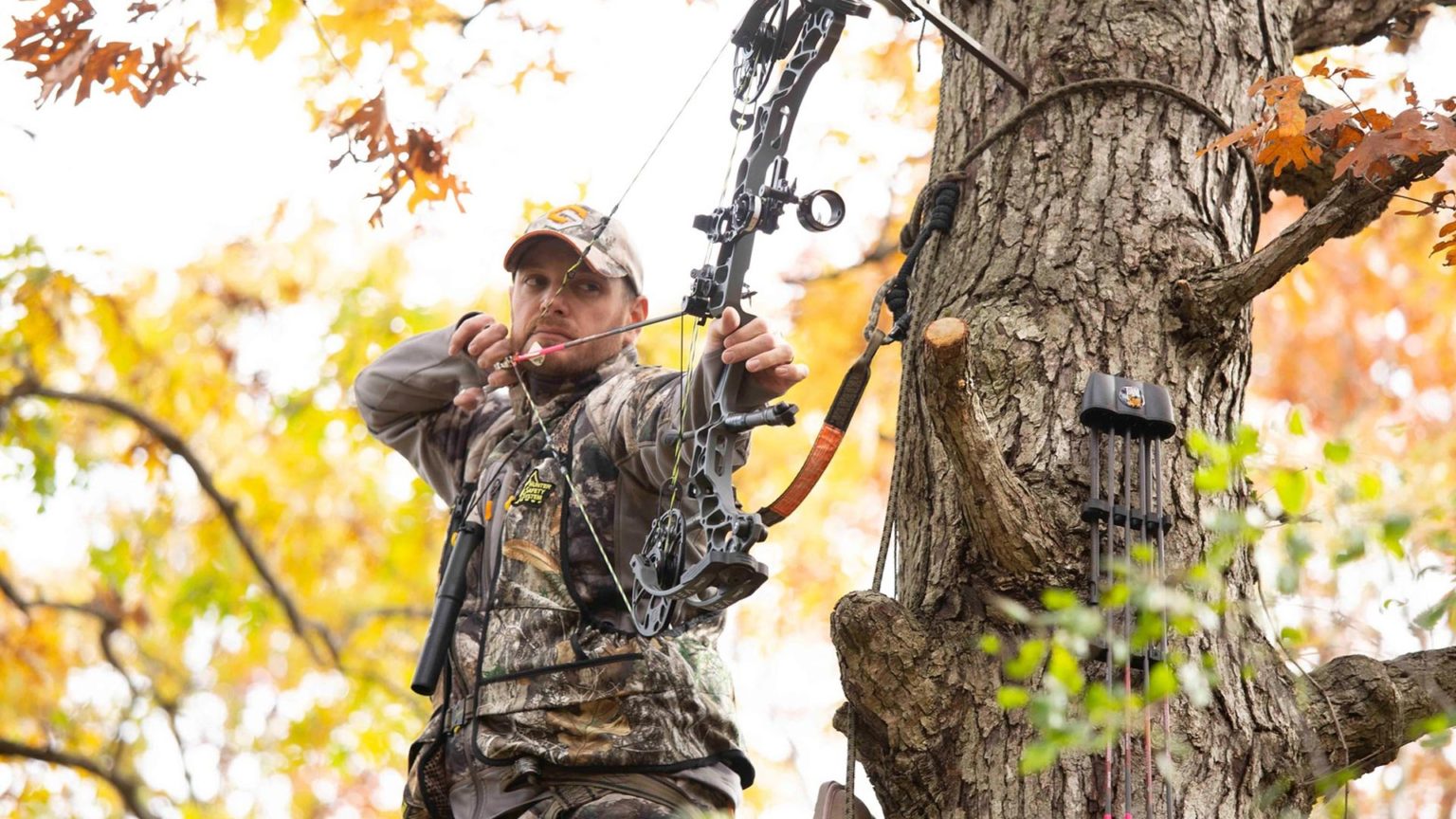 bowhunter at full draw in treestand