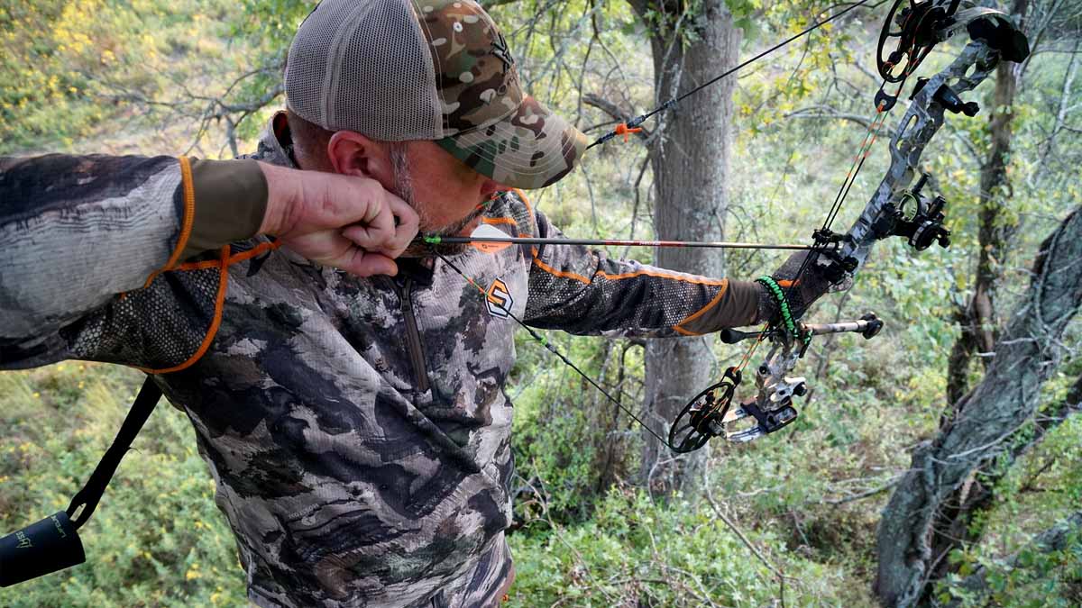 bowhunter at full draw in treestand