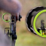 A composite photograph showcasing the HHA XV3 bow sight from two perspectives. On the left, a bowhunter’s first-person view looks through the mounted sight with its bright neon green ring towards a blurred target area. On the right, a sharp product close-up details the HHA XV3 scope, highlighting its textured black housing, bright neon green sight ring, vertical multi-pin configuration, and bubble level.