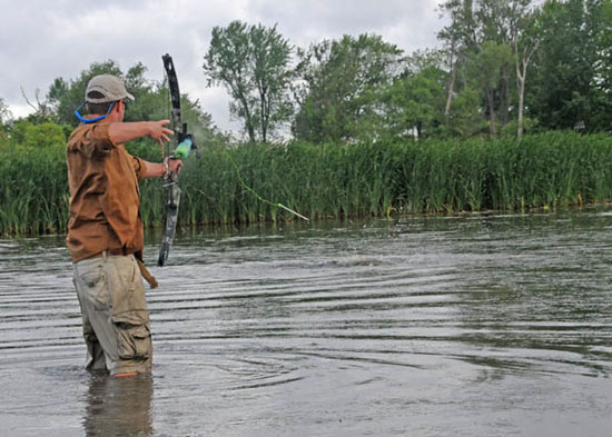 Beau Christensen stalks, aims, and releases an arrow at a pod of spawning carp on Lake Poygan in east-central Wisconsin..