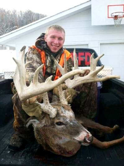 kid in back of truck with big buck